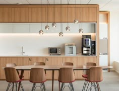 a dining room table with six chairs and a coffee maker on the wall behind it