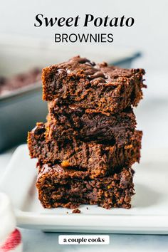 three brownies stacked on top of each other on a white plate next to a baking dish