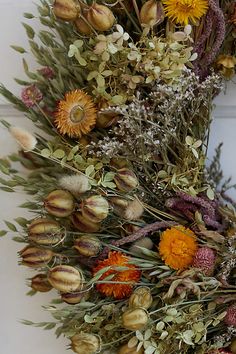 a wreath made out of dried flowers and leaves