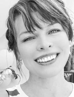 a black and white photo of a woman smiling