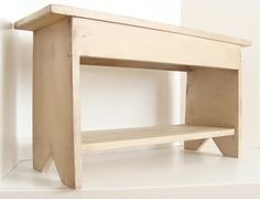 a small wooden shelf sitting on top of a white floor