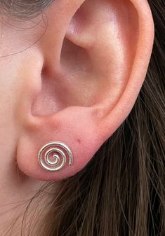 Beautiful textured 925 Sterling Silver Spiral stud earrings. These push back studs look amazing in all light with their delicately brushed finish. Metaphysical Benefits: The spiral is the rhythm of life. It characterizes the creative vital force of human and society, a symbol of unity of generations, and spiritual and moral growth of man. It means the life order, the symbol of continuity, development, motion, and journey into the unknown. Spiral Stud Earrings, Cute Studs Earrings, Cute Unique Earrings, Uneven Ear Piercings, Pretty Silver Earrings, Gold Spiral Jewelry, Cool Silver Jewelry, Cool Earing, Spiral Accessories