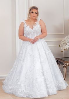 a woman in a white wedding dress posing for the camera with her hands on her hips