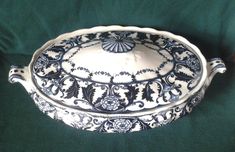 an ornate blue and white dish on a green cloth