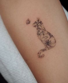 a small tattoo on the arm of a woman's left arm, with flowers growing out of it