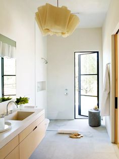 a white bathroom with two sinks and a large mirror above it's sink area