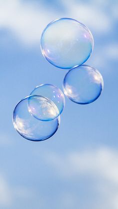 three bubbles floating in the air on a sunny day