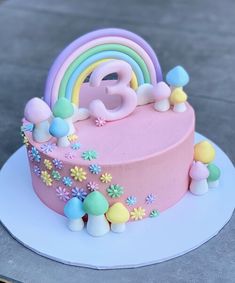 a birthday cake decorated with flowers, rainbows and the number eight on it's side