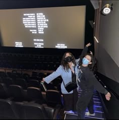 two girls wearing masks in front of a projection screen