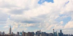 an airplane flying in the sky over a large city with tall buildings and skyscrapers