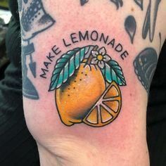 an orange with leaves and flowers on it's arm that says make lemonade