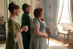 three women standing in a room looking at each other