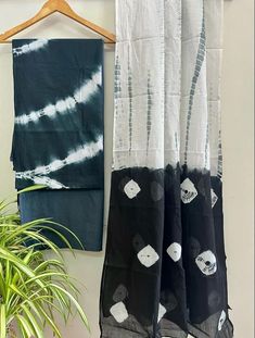 two black and white curtains hanging next to a potted plant