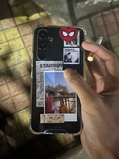 someone holding up their cell phone to take a selfie with the deadpool sticker on it