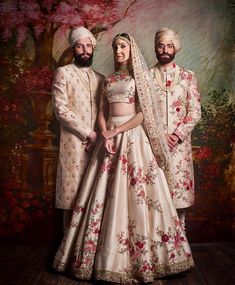 two men and a woman in wedding outfits