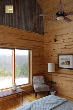 a bedroom with wood paneling and a ceiling fan