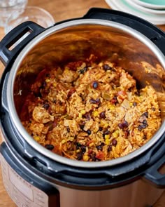 a crock pot filled with food sitting on top of a wooden table