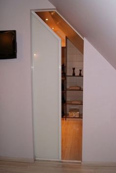 an open closet in the corner of a room next to a tv on a wall