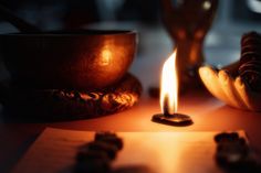 a lit candle sitting on top of a table next to some rocks and other items