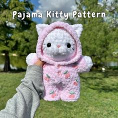 a person holding up a stuffed animal in a pink outfit with the words pajama kitty pattern on it