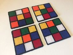 four pieces of colorful beaded coasters sitting on top of a table