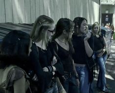 group of women standing next to each other in front of a building