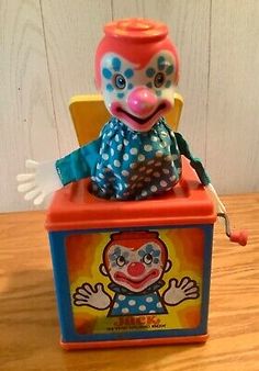 a clown toy sitting on top of a box