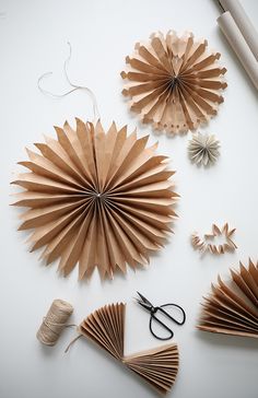 paper fans, scissors and other crafting supplies laid out on a white table top