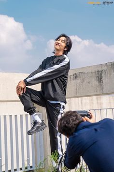 a man in black and white is doing tricks on his skateboard while another person photographs him