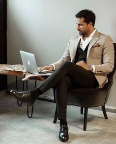 a man sitting in a chair using a laptop computer