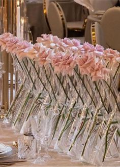 there are many clear vases with pink flowers in them