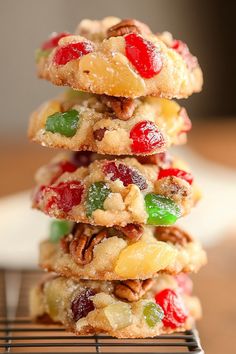 a stack of fruity cookies sitting on top of a metal rack next to a white plate