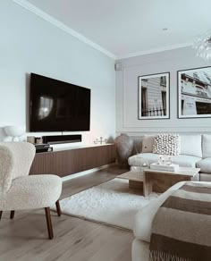 a living room filled with furniture and a flat screen tv mounted to the side of a wall