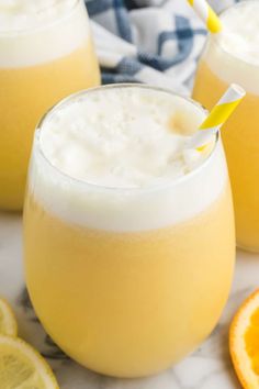 two glasses filled with orange juice and topped with a yellow straw