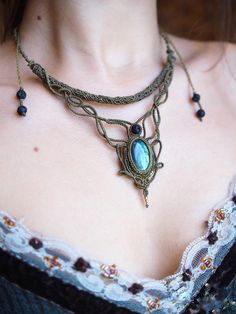 a close up of a woman wearing a necklace with an ornate design on the neck