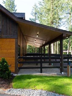 a covered area with benches and trees in the background