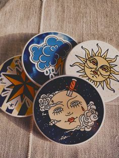 four decorative plates with sun and moon designs on them