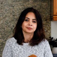 a woman holding a donut in her hands