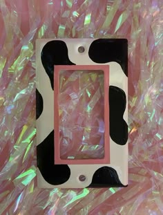 a pink and black cow print frame sitting on top of plastic