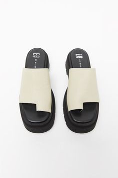 The Maggie sandal elevates your look with a thick 5.8cm sole made from high density EVA rubber that carries a natural weight. The slide is made of soft thick beige leather and features a toe loop for a distinct sporty look. Finished with ultra-cushioned memory foam insoles, leather lining and rubber outsole. Designed in London | Made in Portugal Shoes Europe, Miista Shoes, Elle Shoes, Shoes Closet, Trendy Slippers, Leather Slippers For Men, Crocs Fashion, Bold Shoes, Beige Sandals