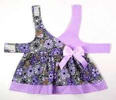 a purple and gray dress with polka dots on the collar, two matching straps and a bow at the waist