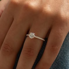 a woman's hand with a diamond ring on top of her finger and an engagement band