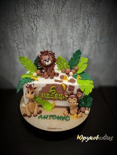 there is a cake decorated with animals and leaves