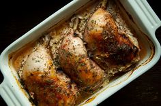 chicken in a casserole dish with herbs on top