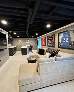 a large living room with couches and basketball memorabilia on the wall, along with other sports memorabilia