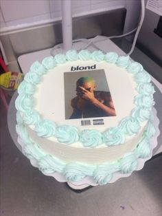 a white cake with blue frosting and a photo on it