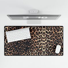 a computer keyboard and mouse on a leopard print placemat with the word 2010 above it