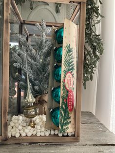 a wooden box filled with christmas decorations on top of a table