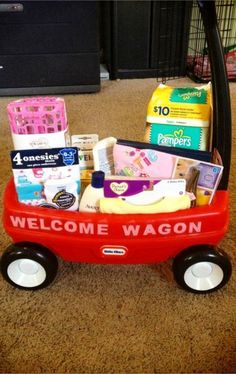 a red wagon filled with lots of items on the floor next to a black basket