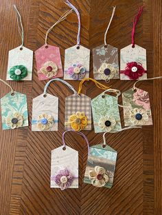 several tags with different designs on them are laid out on a wooden table and tied together